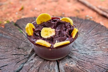 En otantik Brezilya aa 'sı, Euterpe oleracea, minimalist bir kasede muz ve uyumlu bir ortam. Süper gıda enerjisi ve vitaminler