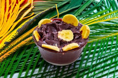 En otantik Brezilya aa 'sı, Euterpe oleracea, minimalist bir kasede muz ve uyumlu bir ortam. Süper gıda enerjisi ve vitaminler