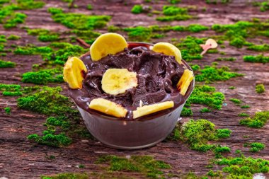 En otantik Brezilya aa 'sı, Euterpe oleracea, minimalist bir kasede muz ve uyumlu bir ortam. Süper gıda enerjisi ve vitaminler