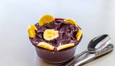 En otantik Brezilya aa 'sı, Euterpe oleracea, minimalist bir kasede muz ve uyumlu bir ortam. Süper gıda enerjisi ve vitaminler