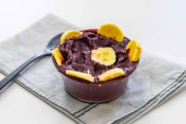 En otantik Brezilya aa 'sı, Euterpe oleracea, minimalist bir kasede muz ve uyumlu bir ortam. Süper gıda enerjisi ve vitaminler