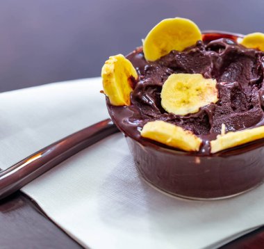 En otantik Brezilya aa 'sı, Euterpe oleracea, minimalist bir kasede muz ve uyumlu bir ortam. Süper gıda enerjisi ve vitaminler