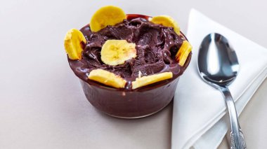 En otantik Brezilya aa 'sı, Euterpe oleracea, minimalist bir kasede muz ve uyumlu bir ortam. Süper gıda enerjisi ve vitaminler