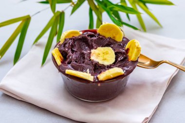 En otantik Brezilya aa 'sı, Euterpe oleracea, minimalist bir kasede muz ve uyumlu bir ortam. Süper gıda enerjisi ve vitaminler