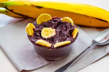 En otantik Brezilya aa 'sı, Euterpe oleracea, minimalist bir kasede muz ve uyumlu bir ortam. Süper gıda enerjisi ve vitaminler