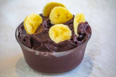 En otantik Brezilya aa 'sı, Euterpe oleracea, minimalist bir kasede muz ve uyumlu bir ortam. Süper gıda enerjisi ve vitaminler