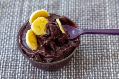 En otantik Brezilya aa 'sı, Euterpe oleracea, minimalist bir kasede muz ve uyumlu bir ortam. Süper gıda enerjisi ve vitaminler