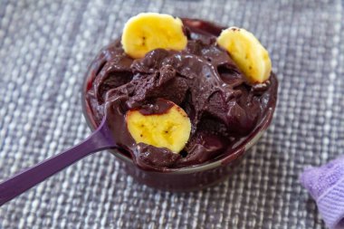 En otantik Brezilya aa 'sı, Euterpe oleracea, minimalist bir kasede muz ve uyumlu bir ortam. Süper gıda enerjisi ve vitaminler