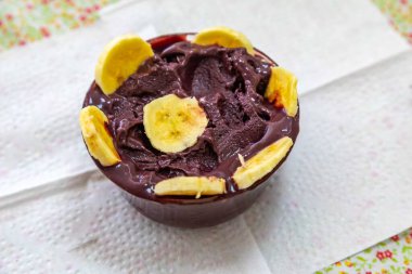 En otantik Brezilya aa 'sı, Euterpe oleracea, minimalist bir kasede muz ve uyumlu bir ortam. Süper gıda enerjisi ve vitaminler