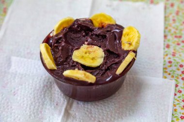 En otantik Brezilya aa 'sı, Euterpe oleracea, minimalist bir kasede muz ve uyumlu bir ortam. Süper gıda enerjisi ve vitaminler