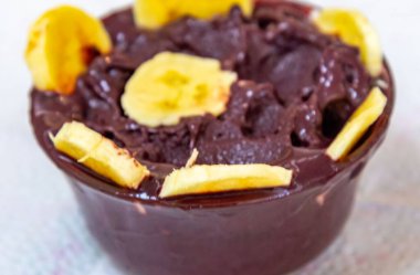 En otantik Brezilya aa 'sı, Euterpe oleracea, minimalist bir kasede muz ve uyumlu bir ortam. Süper gıda enerjisi ve vitaminler