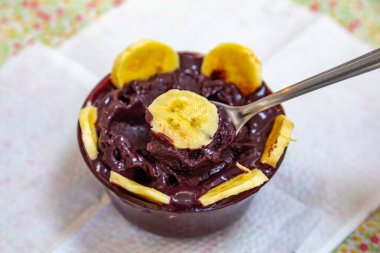 En otantik Brezilya aa 'sı, Euterpe oleracea, minimalist bir kasede muz ve uyumlu bir ortam. Süper gıda enerjisi ve vitaminler