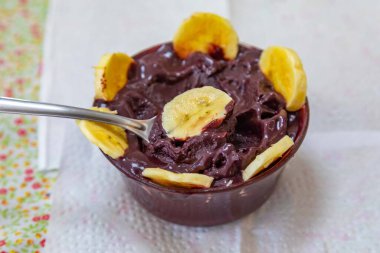 En otantik Brezilya aa 'sı, Euterpe oleracea, minimalist bir kasede muz ve uyumlu bir ortam. Süper gıda enerjisi ve vitaminler