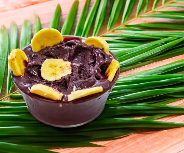 En otantik Brezilya aa 'sı, Euterpe oleracea, minimalist bir kasede muz ve uyumlu bir ortam. Süper gıda enerjisi ve vitaminler