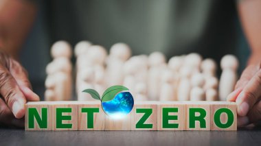 Net Zero and Carbon Neutral Concepts,Helping to plant trees to reduce global warming,Preserving the environment and ecosystems,A man's hand holds a stack of wooden blocks.