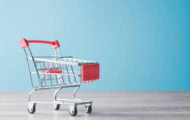 red shopping cart Placed on a wooden floor,Shopping service on The online web and offers home delivery.