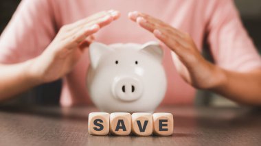 Wooden blocks and piggy bank on the table, money saving concept. Financial and economic investments with profits of success. New ideas for growth in business and banking.