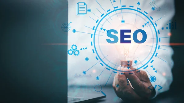 Marketer hold a light bulb showing SEO concepts, optimization analytics tools, search engine rankings, social media sites based on results analytics data. Customers use keywords to connect product