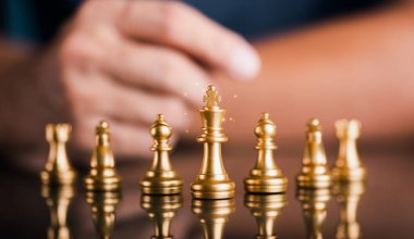 Businessman putting his arm on the table behind a chess piece and thinking , business competition planning strategic idea Teamwork, organization development towards innovation with creativity