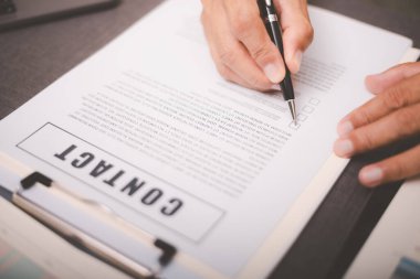 Business owner checking documents and reports and agreements To consider the approval of the business contract, before signing the signature, employment idea, project review, work from home.
