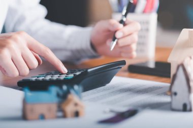 man using a calculator,The concept of a loan for housing,Approval of credit for the purchase of real estate,business and finance concept,home loan refinancing,Residential sale and mortgage planning