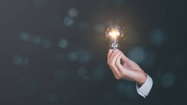 solution concept and demonstrating leadership strategies,Creativity that will lead business in the right direction,with innovation and brain power from brainstorming,businessman holding a light bulb