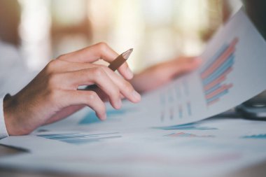 Business people read business statistics chart reports, to analyze and improve corporate strategy, manage financial and marketing documents, update annual budget accounts, company growth data.	