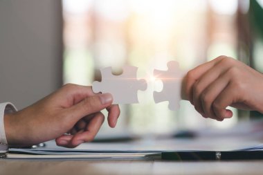 Businessman holding a puzzle piece to find a business solution,Connecting success and problem solution, from creativity,and strategic planning to develop the organization into the future