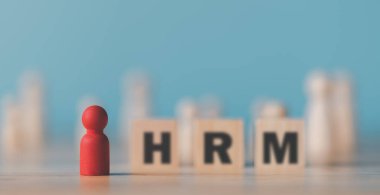 A wooden doll sits on the table,HRM or Human Resource Management,leadership in recruitment,Business development by choosing professional leaders employee competency teamwork,Taregt customer 