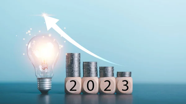 New Year start concepts,Light bulbs, coins on wooden blocks all on the table,saving money for future goals,Business targeting and focus concept,the growth and purpose of the organization,