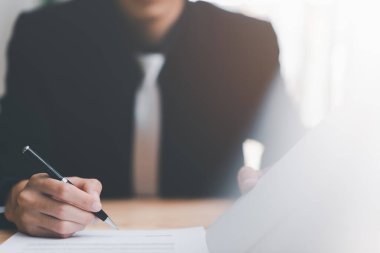 Businessman validates and manages business documents and agreements, signing a business contract approval of contract documents confirmation or warranty certificate,employment idea, project review	