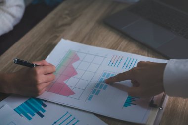 Business people read business statistics chart reports, to analyze and improve corporate strategy, manage financial and marketing documents, update annual budget accounts, company growth data.	