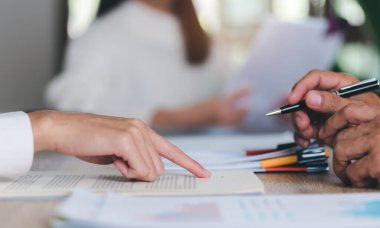 Broker pointing at documents for clients to sign, handling business documents and agreements business contract signing Approval of contract or warranty documents,investment loan approval