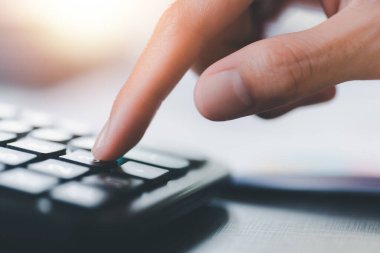 Businessman calculating figures in company financial documents with a calculator,analysis of company financial data,Planning to assess and review budgets,concept of finance and investment 