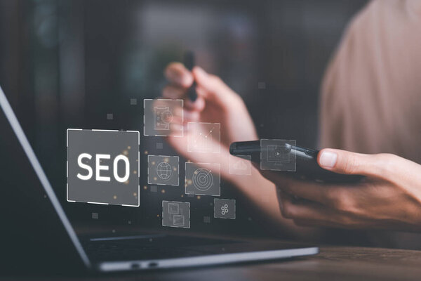 Marketer holding smartphone and showing SEO icon,optimization analysis tools,search engine rankings,social media sites based on results analysis data,Ranking the best sites for search,online marketing