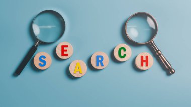Magnifying glass and wooden block on blue background,Keyword search concept to find information from online websites, optimization analysis tools, SEO ,searching for information in the internet world