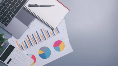 Calculators, laptops and notebooks are placed on the table