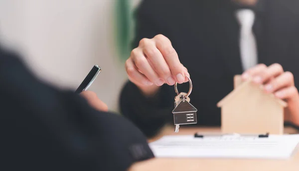 agent broker holding house keychain, handle business documents and agreements, Business contract signing, business cooperation, commercial signing, Signing an agreement ,real estate purchase agreement