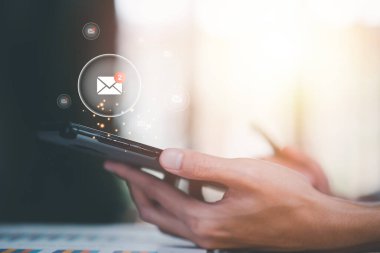 man reading electronic mail from smartphone,Email marketing and newsletter concept,Digital communication with email messages,Sending and receiving messages online with the email icon