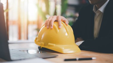 Architects use laptops to detail their work, hard safety helmet on table, protection against danger, Work Safety Concept ,safety care from an accident, prevention of possible injuries, safety first,