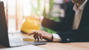 Architects use laptops to detail their work, hard safety helmet on table, protection against danger, Work Safety Concept ,safety care from an accident, prevention of possible injuries, safety first,