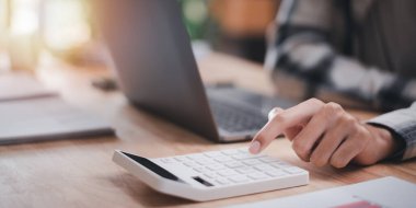 Bir muhasebeci, şirket performansının, maliyet analizinin, mali evrakların, iş hesaplarının, yıllık bütçe planlamasının hesaplarını hesaplamak için hesap makinesi kullanıyor.