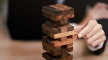 İş adamı Jenga ahşap kutusunu çekiyor, koruma ve risk yönetimi, hatalı koruma, mali denge, mali risk yönetimi konsepti, ticari çıkarların korunması, iş kararları