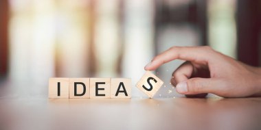 Ahşap bloklar ve eller masanın üzerinde, yaratıcı düşünce, fikirler ve yenilik, yaratıcılığı modern teknolojiye bağlamak, iş problemlerini çözmek için yeni çözümler bulmak, ilham bulmak,