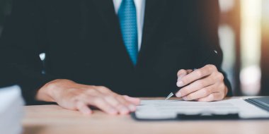 İş adamı kontrat belgelerini kontrol ediyor, iş belgelerini ve anlaşmaları hallediyor, iş sözleşmesi imzalıyor, iş birliği yapıyor, sözleşmeyi veya garanti belgelerini onaylıyor