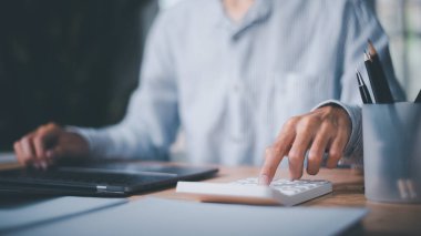 Şirket performansı, maliyet analizi ve mali belgelerin hesaplanması, iş hesapları hesaplamasında hesap makinesi kullanan iş adamı. 