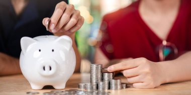 Para biriktiren çift, kişisel finans planlaması, tasarruf alışkanlıkları, finansal eğitim ve bireyler veya aileler için gelecekteki zenginlik yönetimini gösteriyor..