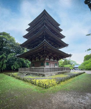 Görkemli beş katlı bir yapı, tipik Japon mimarisi, yemyeşil ve yumuşak mavi gökyüzü ile çevrili, doğayla bir huzur ve uyum hissi veriyor..