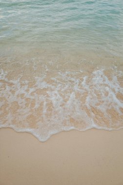 Dalgalar tarafından üretilen kumsaldaki köpüğün detaylı bir fotoğrafı, bu fotoğraf sakin, rahat ve mutlu bir ruh hali yaratıyor..