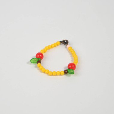 El yapımı boncuklardan yapılmış sarı bilezik, beyaz arka planda resmedilmiş..